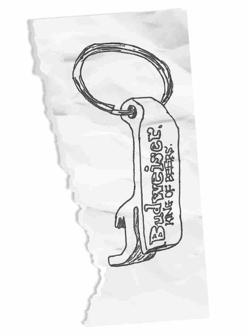 A wrinkled torn piece of paper with a bottle opener-key chain drawn on it. ‘Budweiser King of Beers’ is written on the bottle opener.