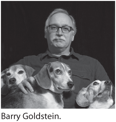 A photo of Jim Shepard with three dogs.