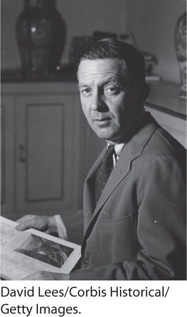 A photo of John Cheever seated with a book in his hands.