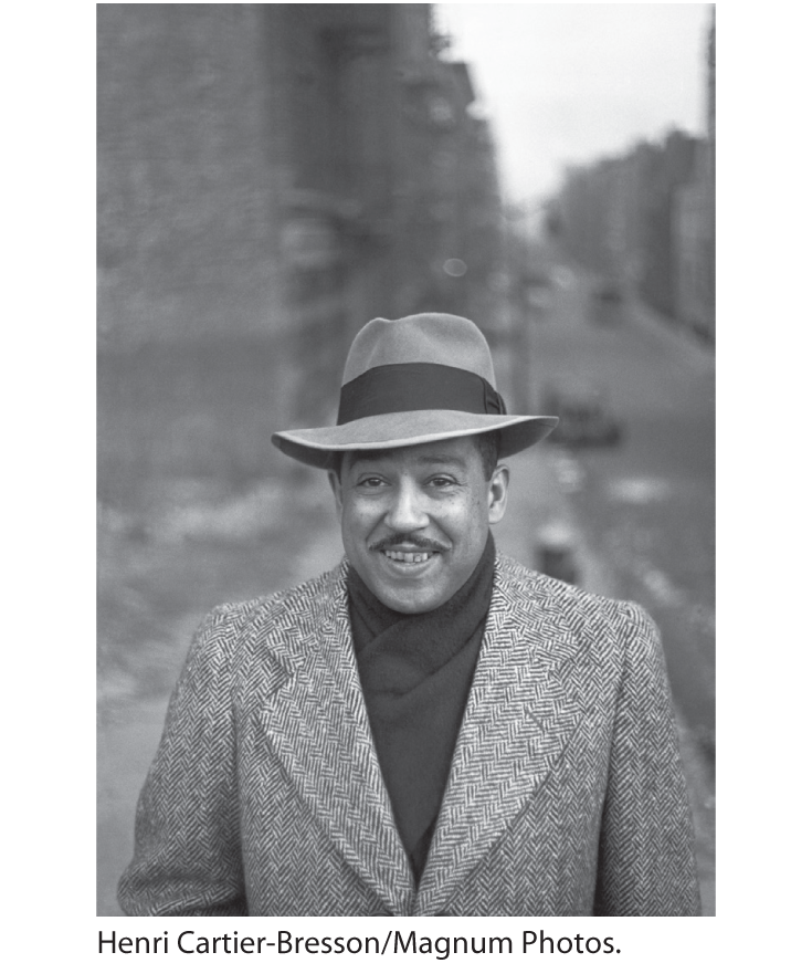 A photo of Langston Hughes, clad in a suit and hat.