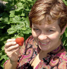 Co-author Lisa Kivirist with one of her fresh strawberries harvested from her organic growing fields. Always remember to eat the strawberry. JOHN D. IVANKO