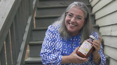 Liz with a jar of The Happy Tomato’s Marinara sauce. COURTESY OF THE HAPPY TOMATO