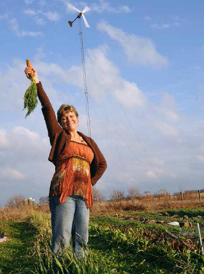 Lisa Kivirist with carrot on farm completely powered by wind and sun. JOHN D. IVANKO