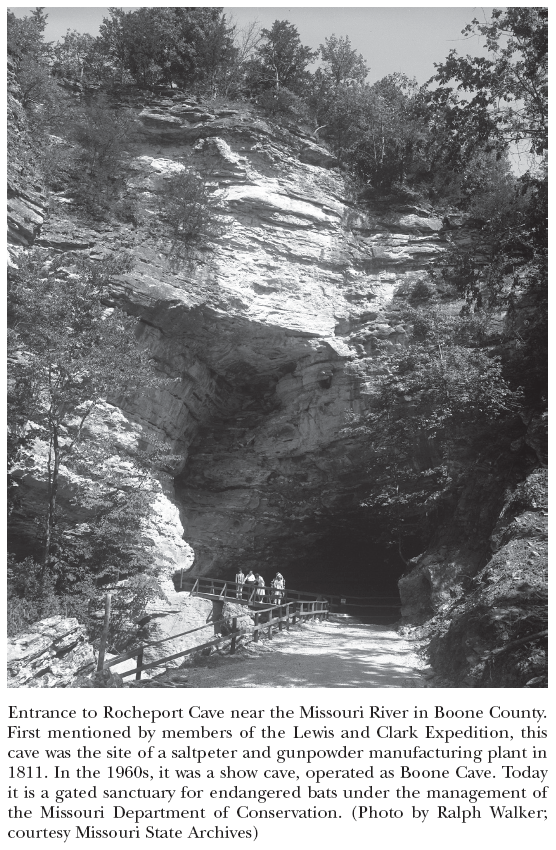 Image: Entrance to Rocheport Cave near the Missouri River in Boone County. First mentioned by members of the Lewis and Clark Expedition, this cave was the site of a saltpeter and gunpowder manufacturing plant in 1811. In the 1960s, it was a show cave, operated as Boone Cave. Today it is a gated sanctuary for endangered bats under the management of the Missouri Department of Conservation. (Photo by Ralph Walker; courtesy Missouri State Archives)