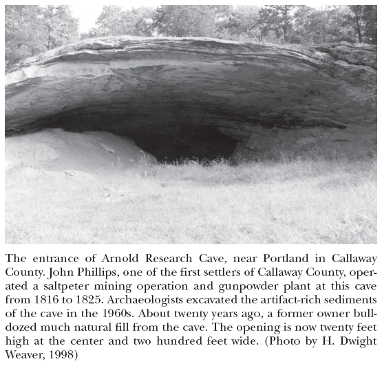 Image: The entrance of Arnold Research Cave, near Portland in Callaway County. John Phillips, one of the first settlers of Callaway County, operated a saltpeter mining operation and gunpowder plant at this cave from 1816 to 1825. Archaeologists excavated the artifact-rich sediments of the cave in the 1960s. About twenty years ago, a former owner bulldozed much natural fill from the cave. The opening is now twenty feet high at the center and two hundred feet wide. (Photo by H. Dwight Weaver, 1998)