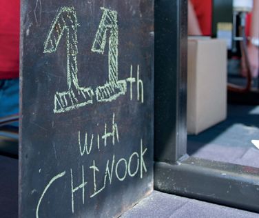 Chalkboard sign reading “11th wtih Chinook”