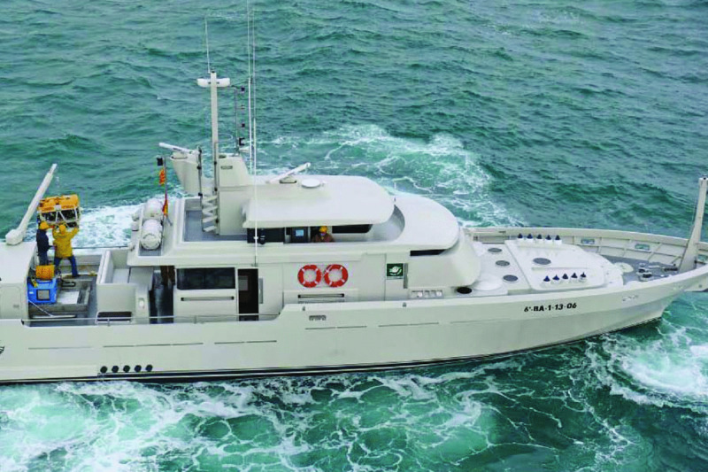 Photograph shows survey boat for ROV inspection to 400 m of water depth, where two men stand holding something and boat needs only three crew members to sail.