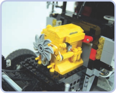 The hood of my tow truck model housed a replica of the original caterpillar engine and a Power Functions battery, located between the engine and the front of the cabin. The red connector piece adjacent to the engine functioned as the model’s master power switch.