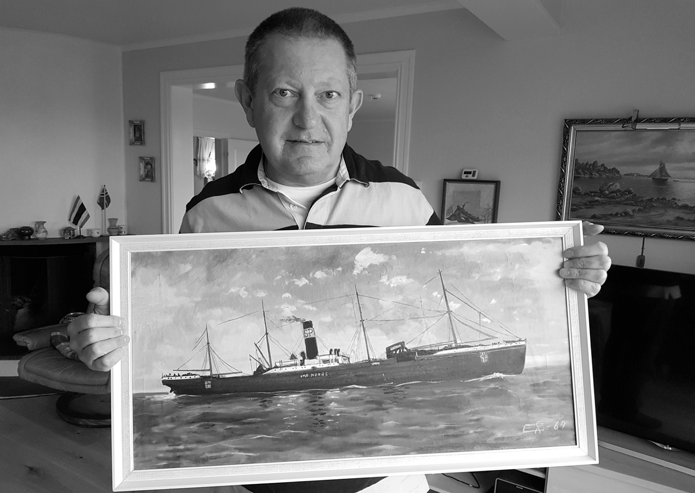 Photograph of Per Hunstok holding a framed painting of the IMO ship.