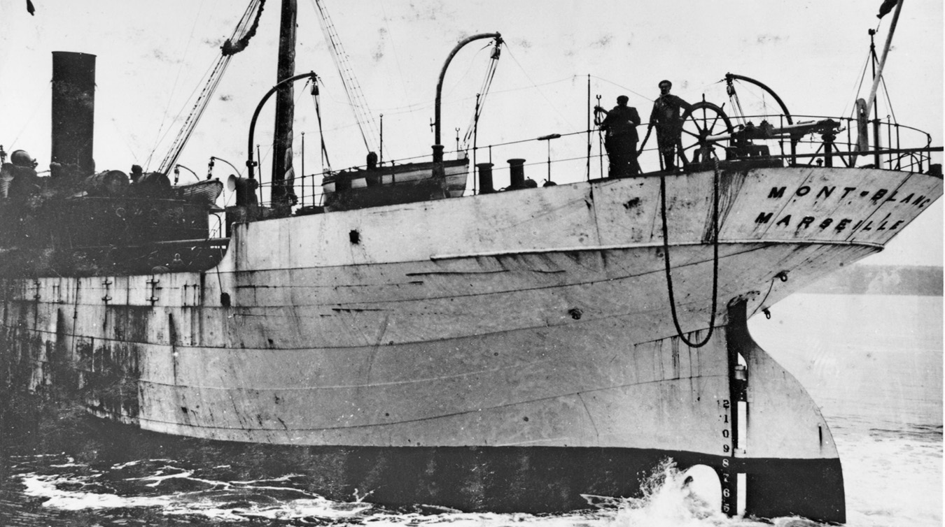 Photograph shows the Stern of Mont-Blanc before explosion. Two people stand on the deck.