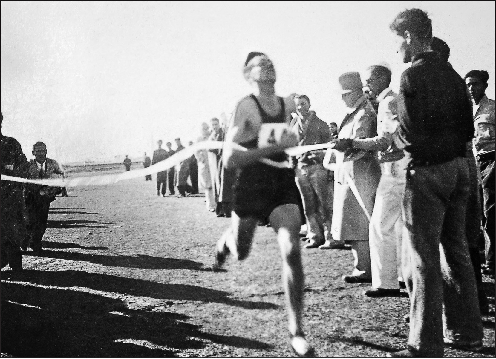 Louie wins the 1933 UCLA two-mile cross-country race by more than a quarter of a mile. Pete is running up from behind to greet him.