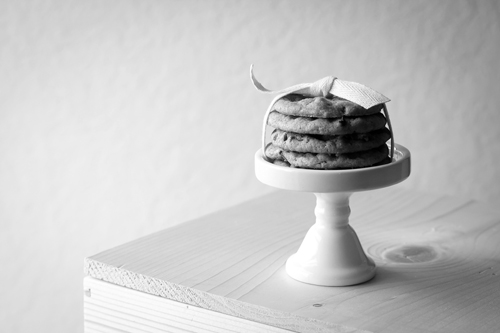 Image of a plate of four warm chocolate chip cookies on the table.