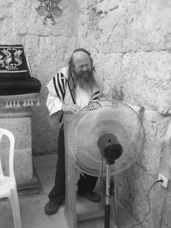 Rabbi praying in front of a fan