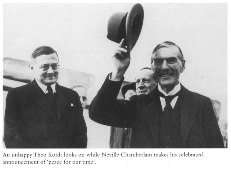 An unhappy Theo Kordt looks on while Neville Chamberlain makes his celebrated announcement of ‘peace for our time’.