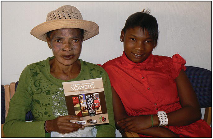 Photo of two African women. The older holds a booklet titled Living with heart failure in Soweto.