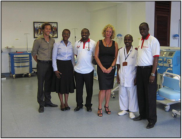 Photo of six people in a hospital, two of which are male African doctor (with stethoscope) and nurse.