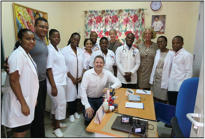 Photo of a group of African medical practitioners in a clinic with 3 Caucasians.