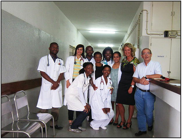 Group photo of African and Caucasian doctors and nurses in a hospital hallway.