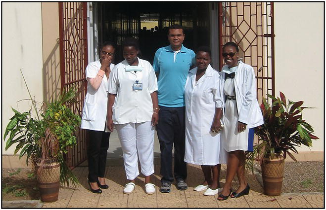 Group photo of five Africans by a doorway.