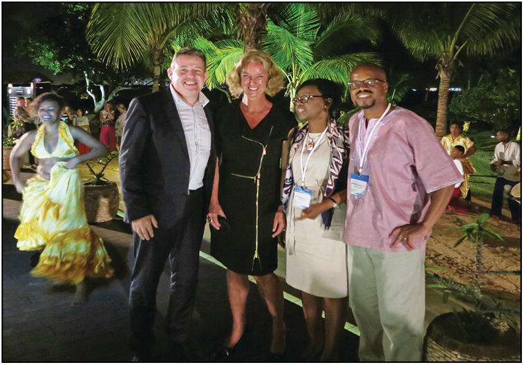 Group photo of two Caucasians and two Africans in an evening party.