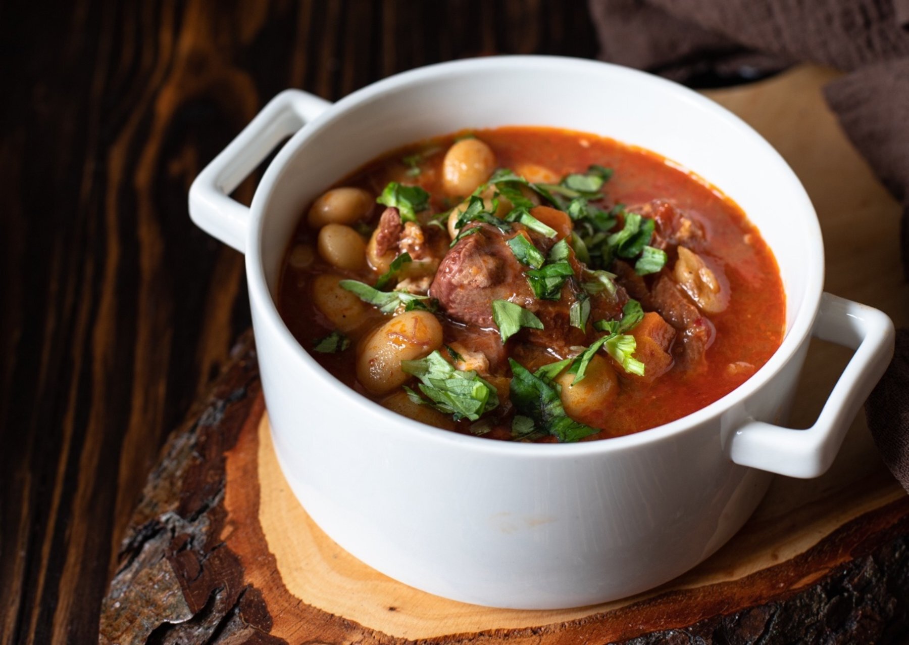 A bowl of soup with meat and vegetables in it Description automatically generated with low confidence