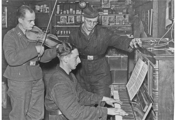 Liselotte Purper: off-duty anti-aircraft personnel playing duets in the bunker of the Anhalter Bahnhof, Berlin.