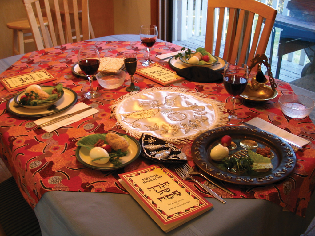 table with ceremonial books, plate with ritual foods, wine glasses