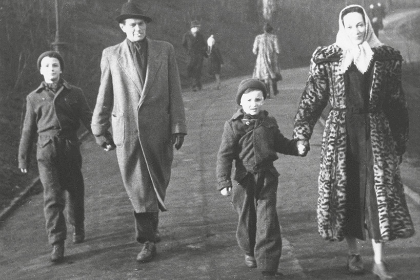 Foto von Eberhard Keindorff und seiner zweiten Frau Sybille Freybe mit deren beiden Söhnen, winterlich gekleidet, beim Spaziergang. Er hält das ältere, sie das jüngere Kind an der Hand.