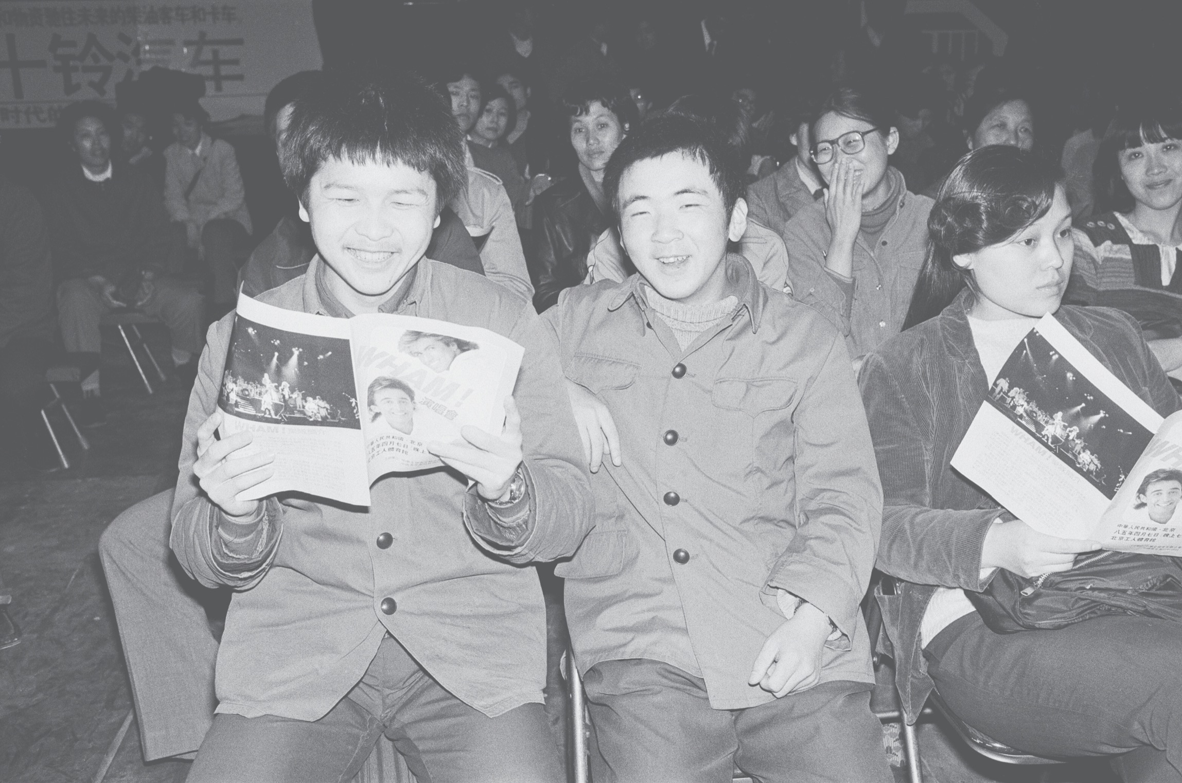 Fans, holding their programme, enjoy the performance of George Michael and Andrew Ridgeley from Wham! in China. 1985. Wham! were on a 10 day tour. In 1985 China was waking up to the world outside after their own Cultural Revolution, and Wham! were the first western band to play in Communist China, circa 9th April 1985. (Photo by Kent Gavin/Daily Mirror/Mirrorpix/Getty Images)