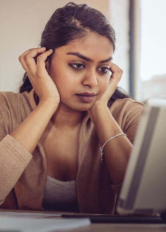 A photo showing a woman looking at her computer.