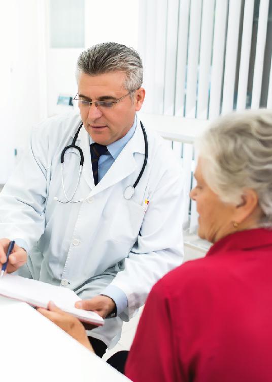 A photo of a doctor having a discussion with his patient while pointing to information on a pad of paper.