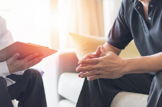 A photo of a doctor having a frank conversation with his patient to help alleviate anxiety.