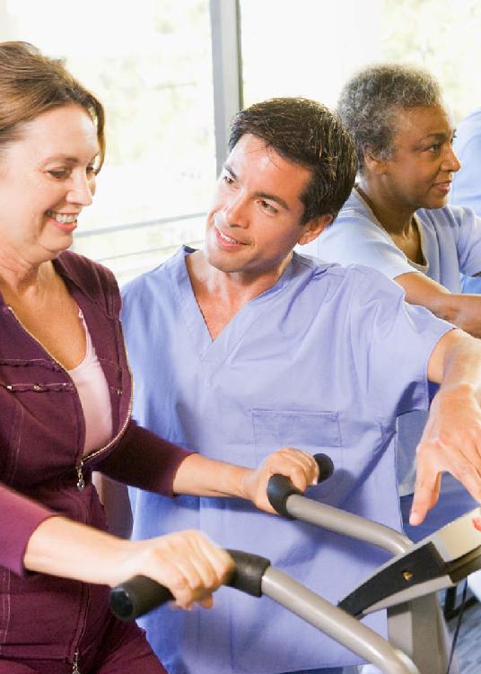 A photo of a woman on a treadmill receiving guidance from her doctor.