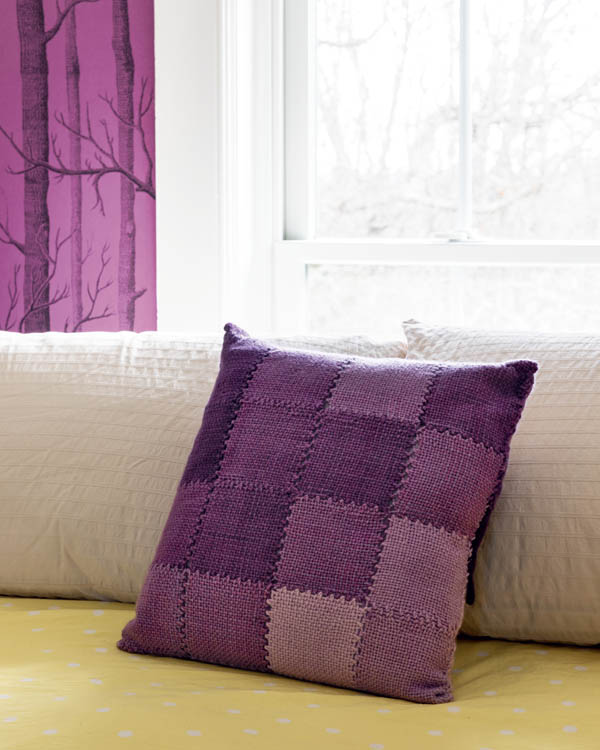 A color-play pillow on a bed