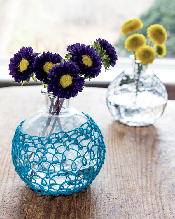 A glass flower vase with knotless netting