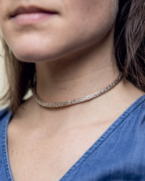 A woman wearing a choker chain necklace