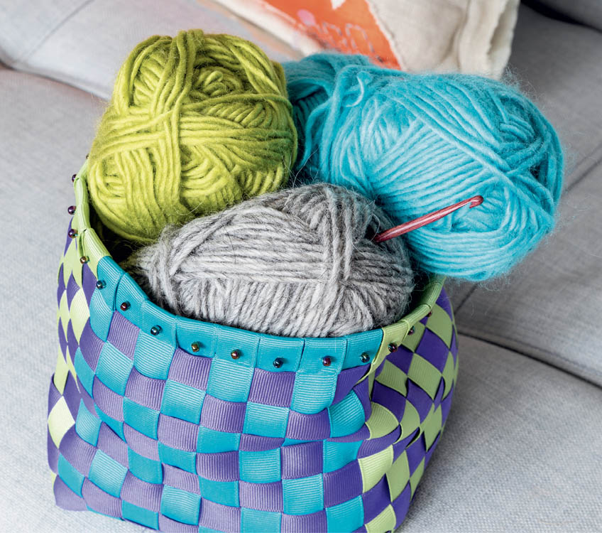 A finished ribbon basket filled with bundles of yarn