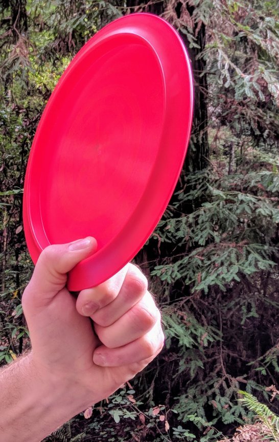 A hand holding a red frisbee  Description generated with high confidence