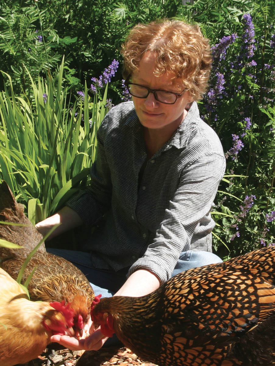 Amy Stewart feeding her chickens.