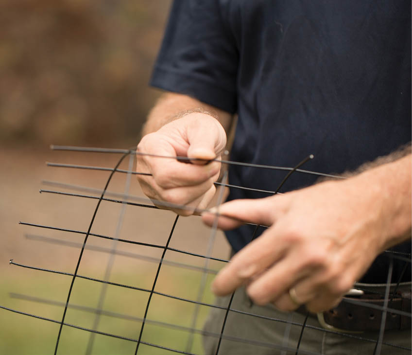 Bending the wire fence into shape.