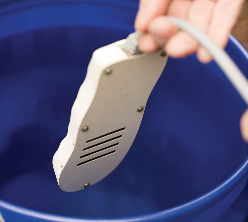 Lowering the de-icer into the bucket.