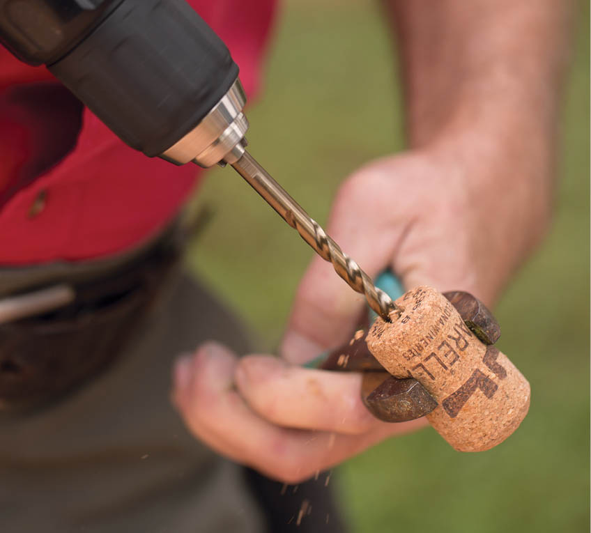 Drilling into the end of the cork.