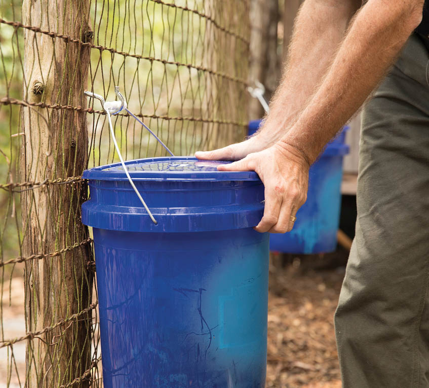 Hanging the bucket onto a fence post.