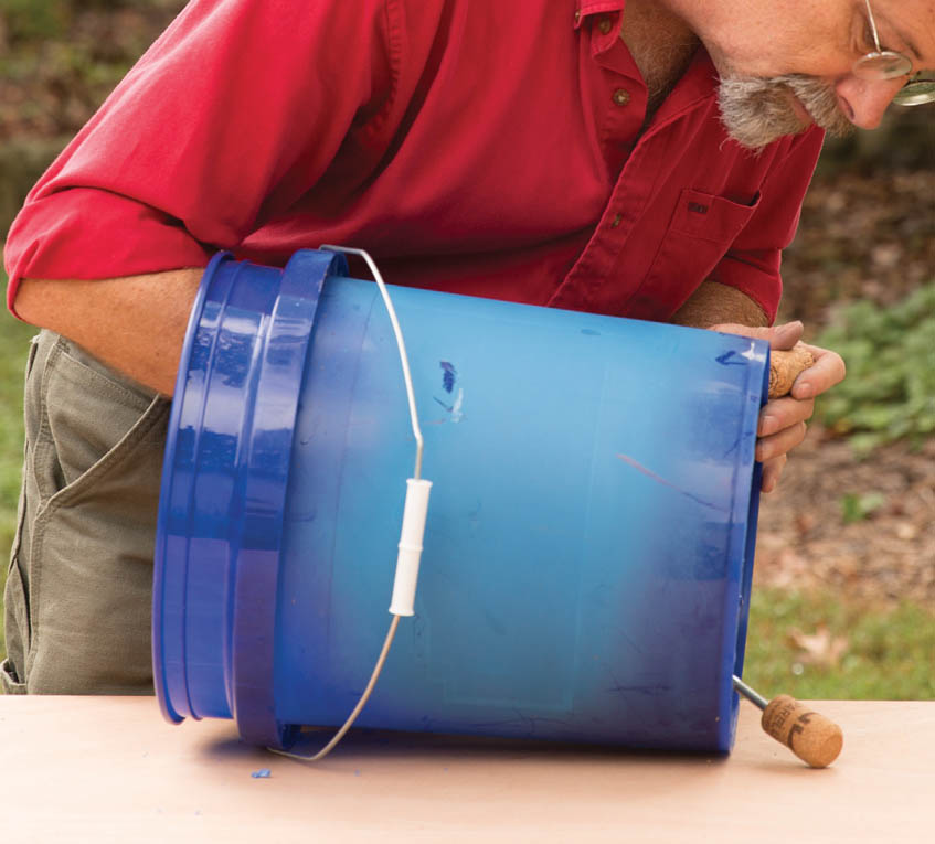 Screwing the cork onto the bottom of the bucket.