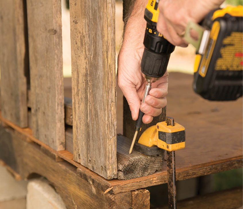 Drilling in screws in the upright pallets.