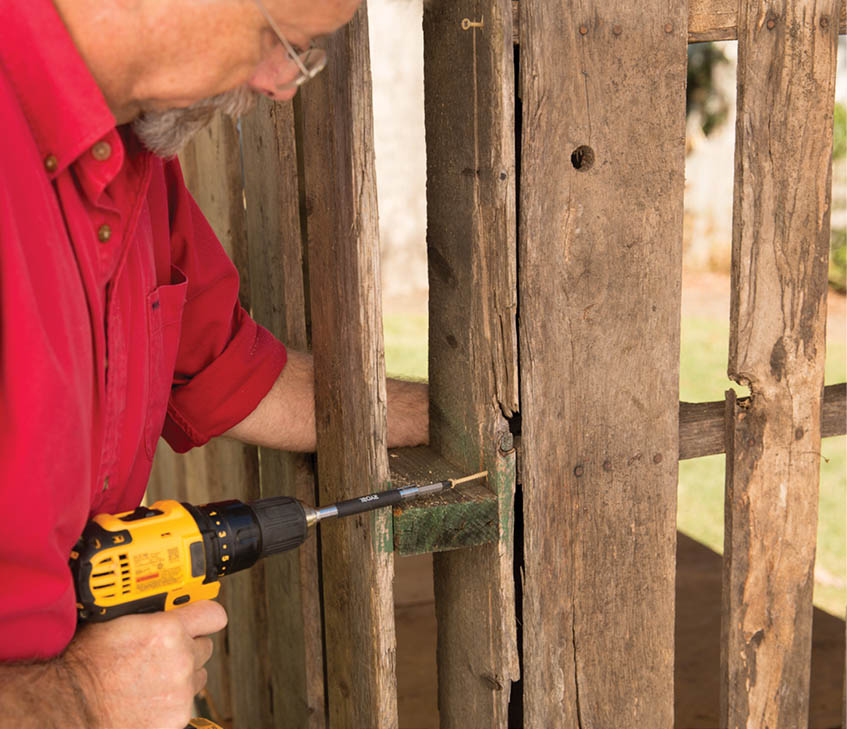 Drilling in screws to attach the pallet walls.