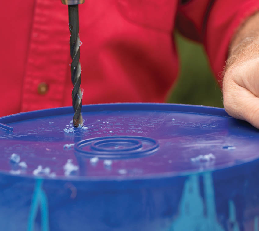 Drilling holes into the bottom of the bucket.