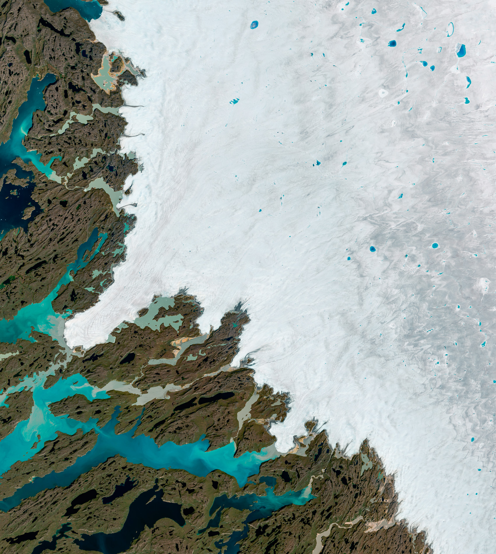 Seen from space, the melt water lakes show as flecks of blue on the Greenland ice cap. © NASA USGS.