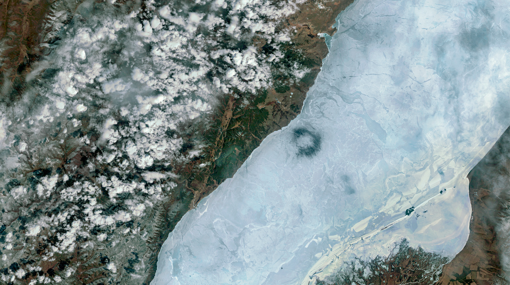 ICE ART The black rings of thin ice on Lake Baikal are most clearly visible from space. They are 5-7 kilometres in diameter, and one or two often appear in spring. Warm eddies below the ice are thought to account for them. © NASA USGS.