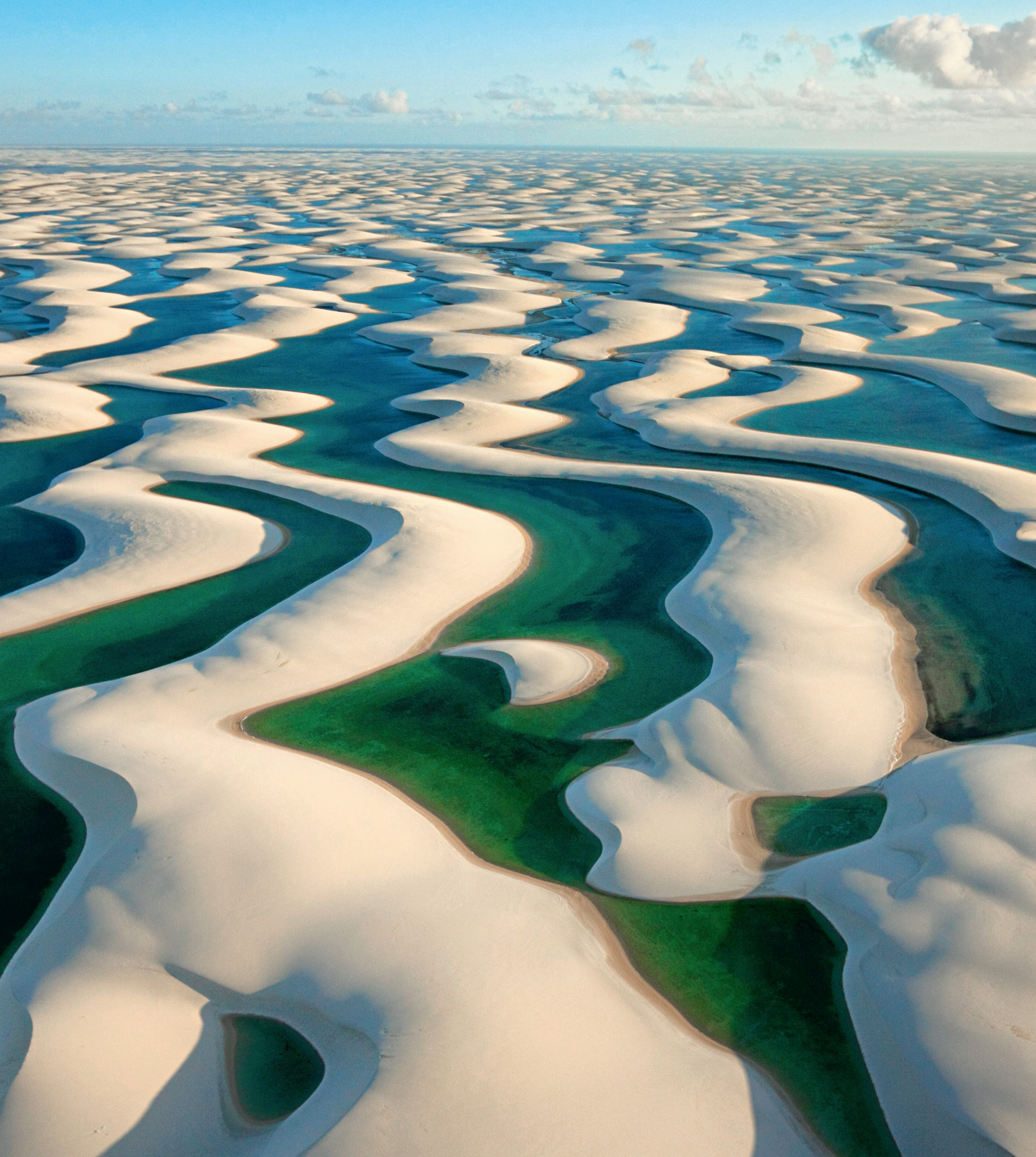 Lençóis Maranhenses may look like a desert, but every rainy season 1,195 millimetres of rain transforms the landscape. The water accumulates as clear lagoons in troughs between the dunes.